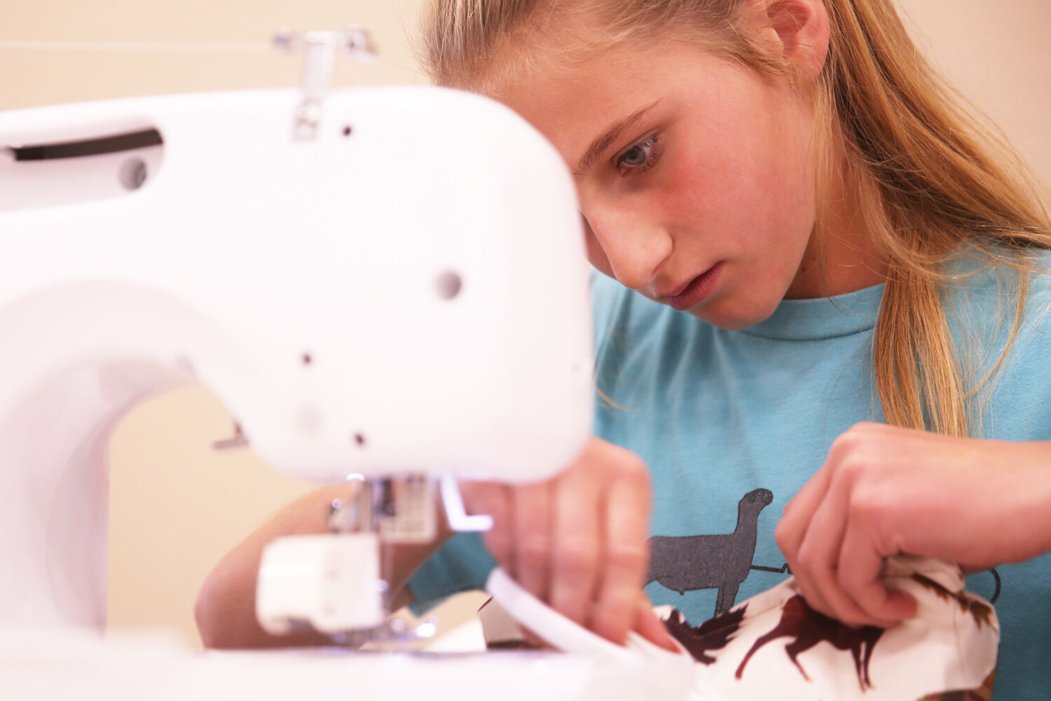 Jolene Foss, 12, looks to cut the extra thread